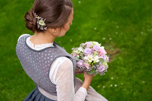 Braut im Trachtenkleid mit Blumenstrauß, Rückenansicht der Frisur