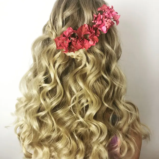 Blonde Lockenmähne mit roten Blüten
